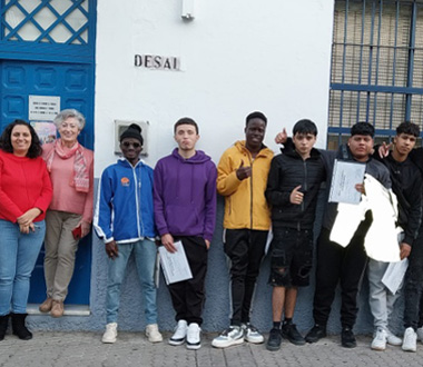 Grupo de jóvenes y personas adultas posando frente a la entrada de la Asociación DESAL. Algunos sostienen diplomas o carpetas, sugiriendo el cierre de una actividad o entrega de certificados.